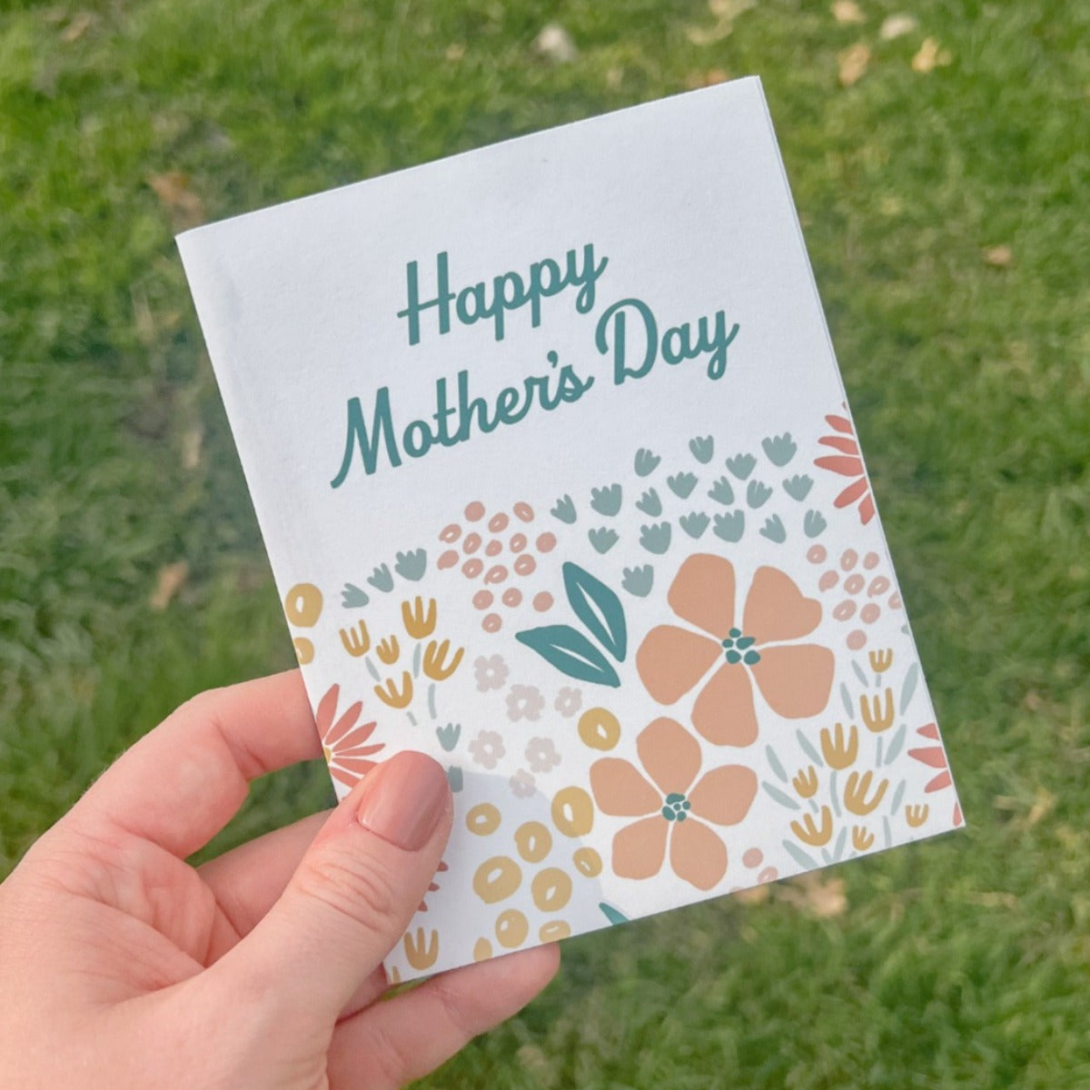 Floral Mother's Day Card being held over grass