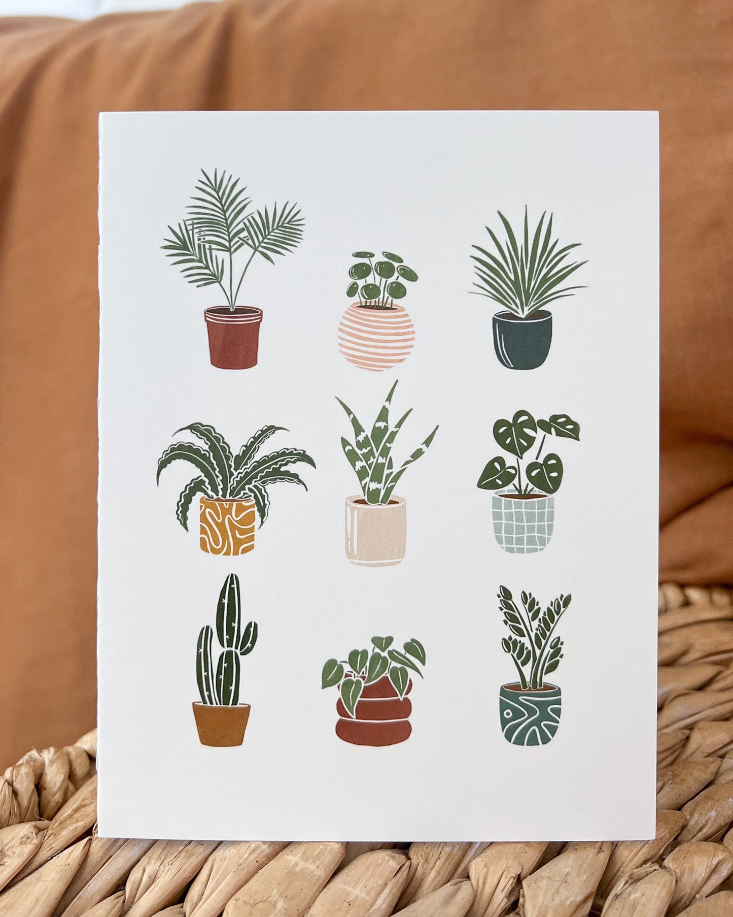 Greeting card with 9 plants in fun colorful pots on white background.