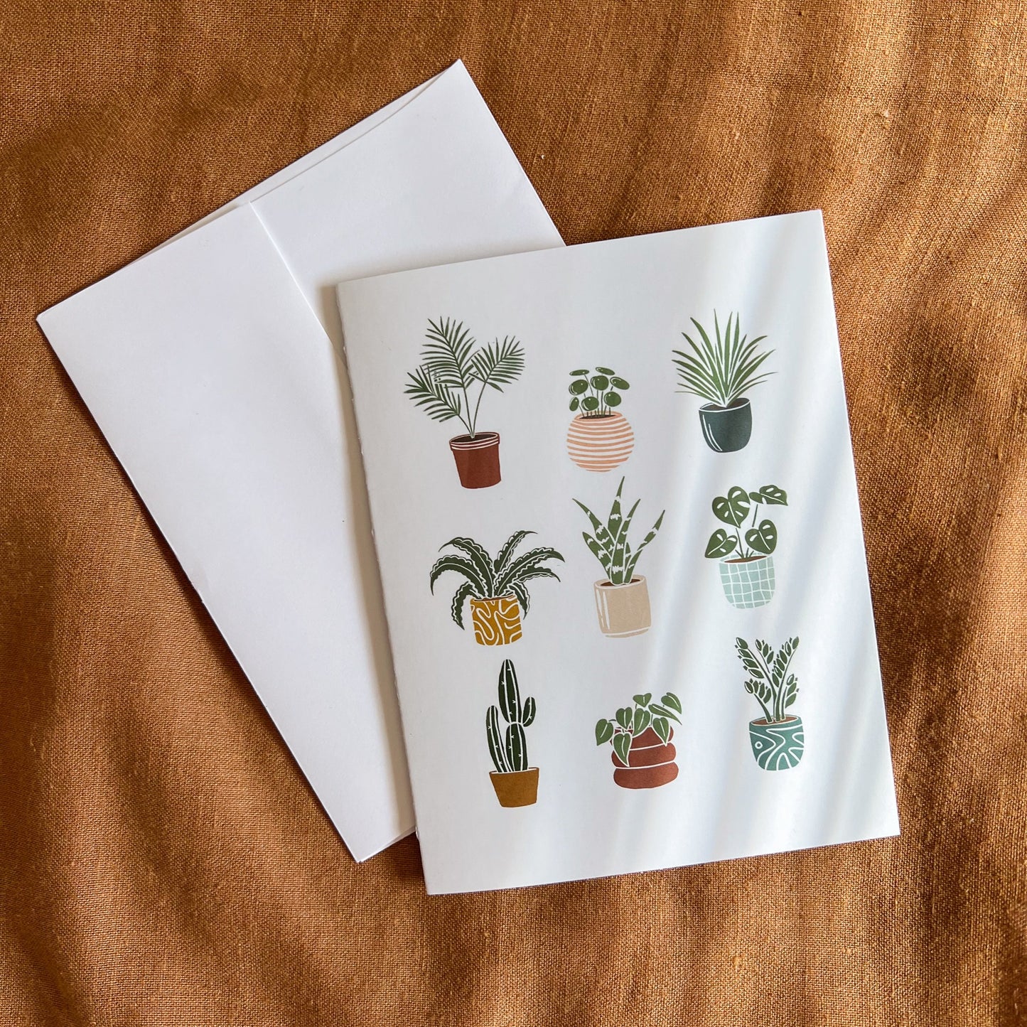 Plant greeting card on a rust fabric background