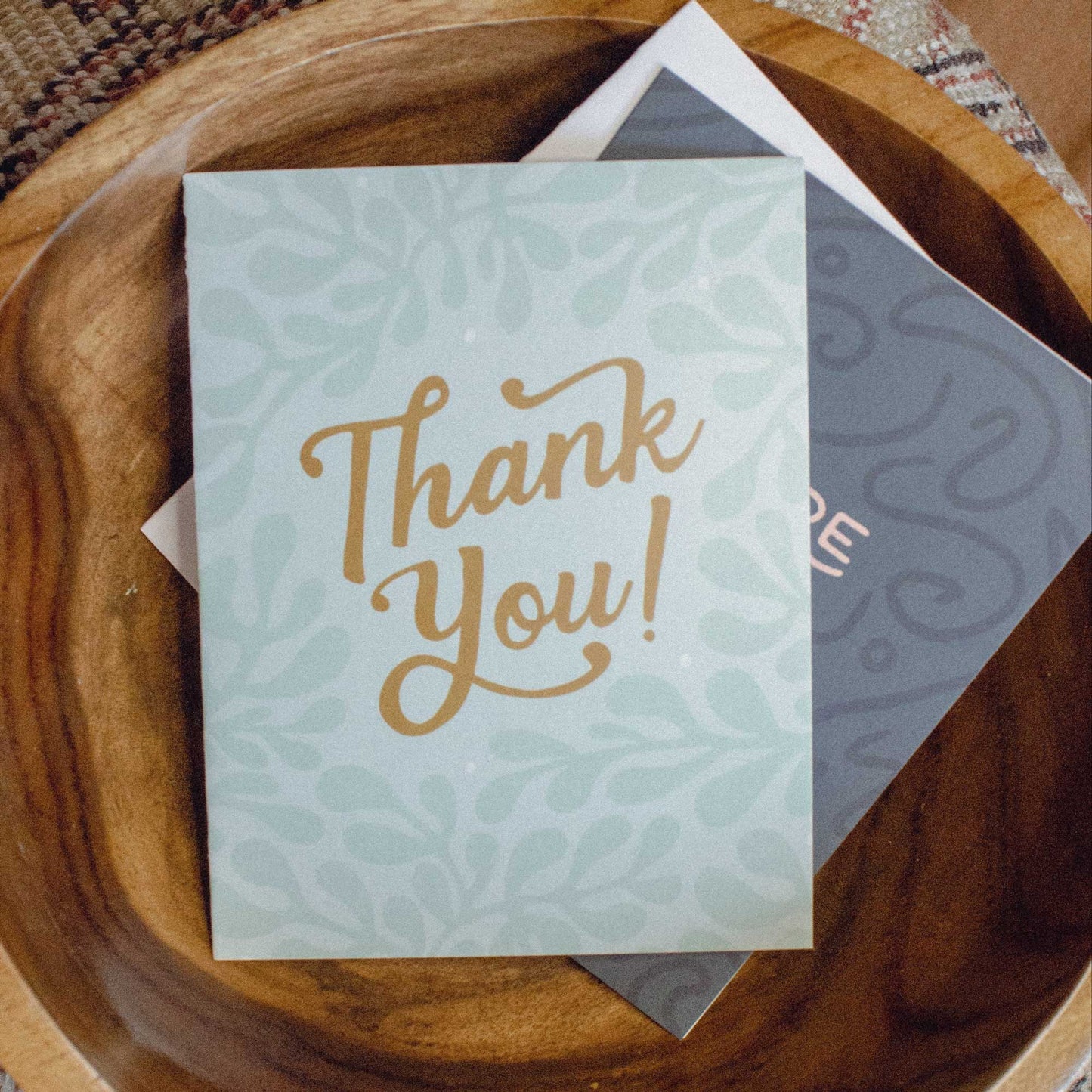 Mixed card pack in a teak bowl on a southwestern embroidered pillow