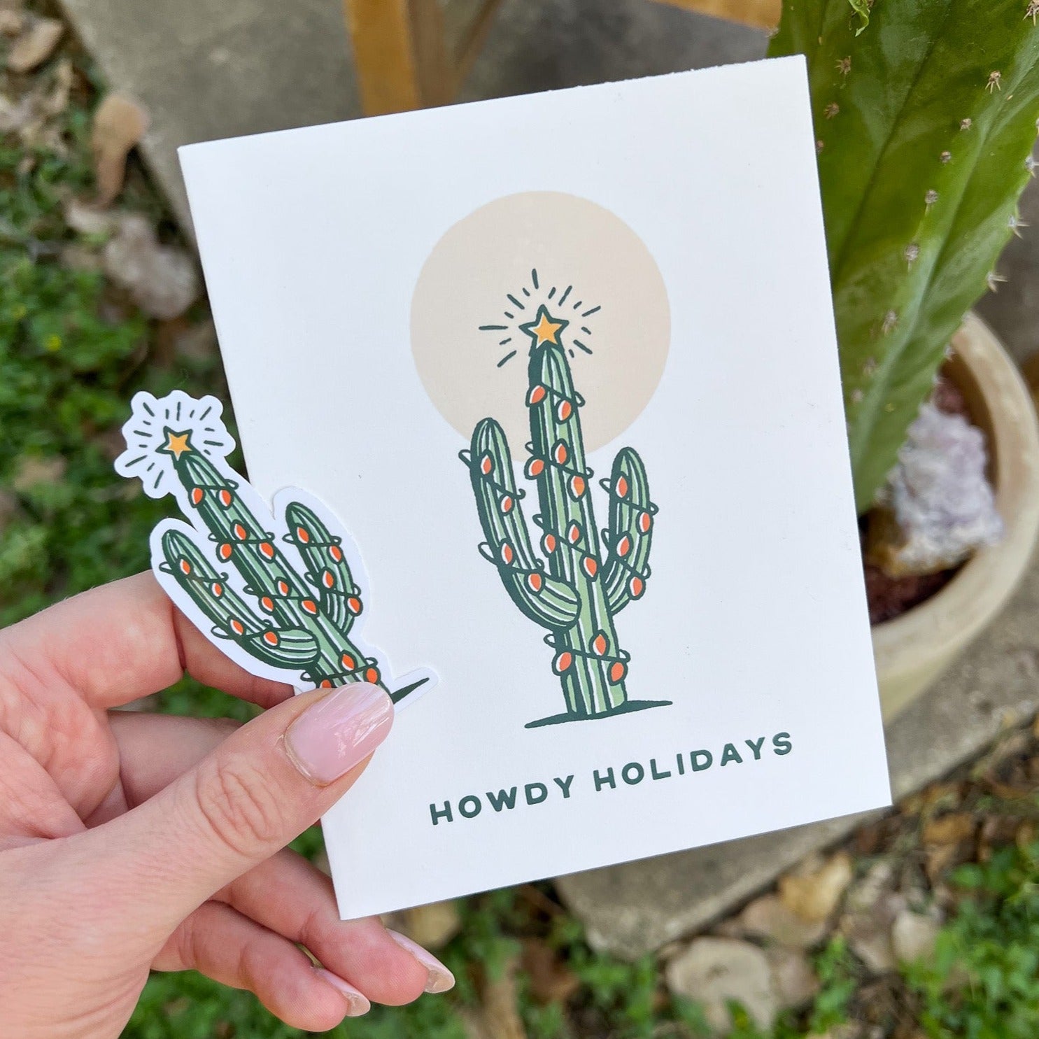 Saguaro Cactus with holiday lights and the message " Howdy Holidays"