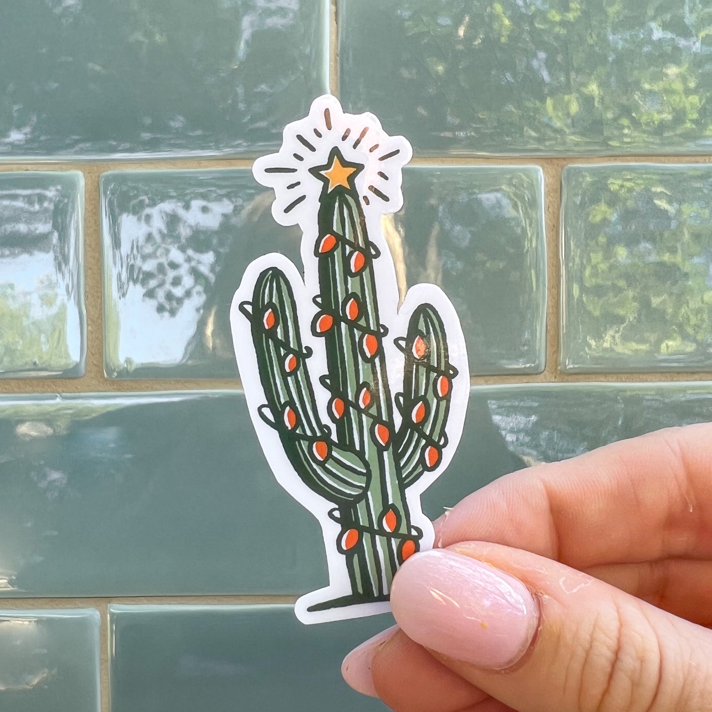 Saguaro Cactus with holiday lights and the message " Howdy Holidays"