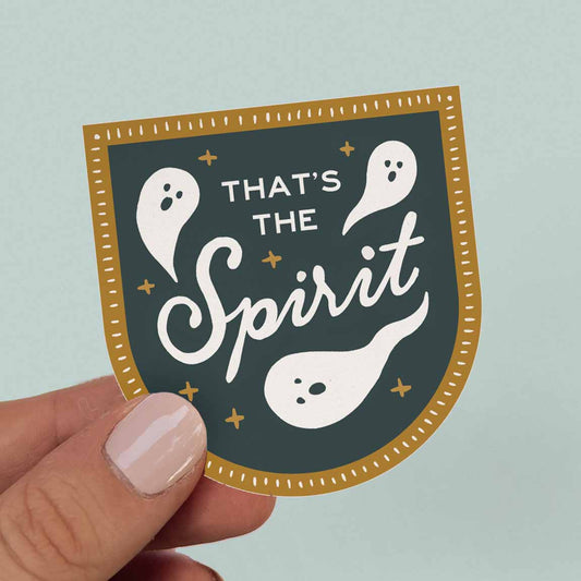 Navy Blue and Gold sticker saying "That's The Spirit" with illustrations of cartoon ghosts. 