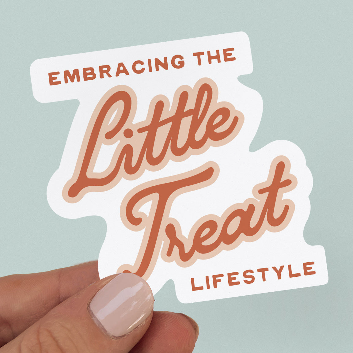 Blue background featuring a sticker with the quote "Embracing the Little Treat Lifestyle" in pink and red