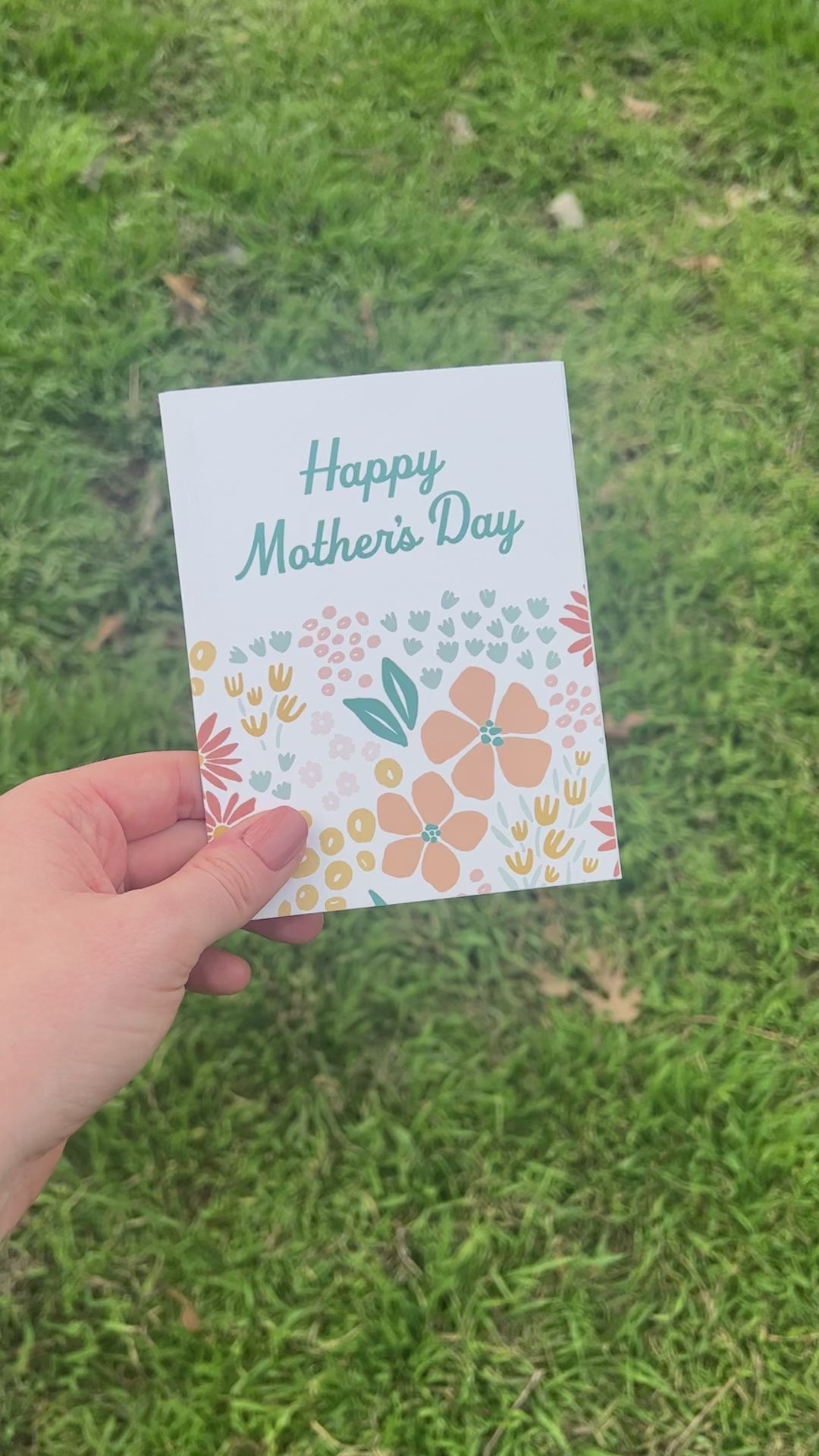Front and Back of floral mother's Day Card held over grass