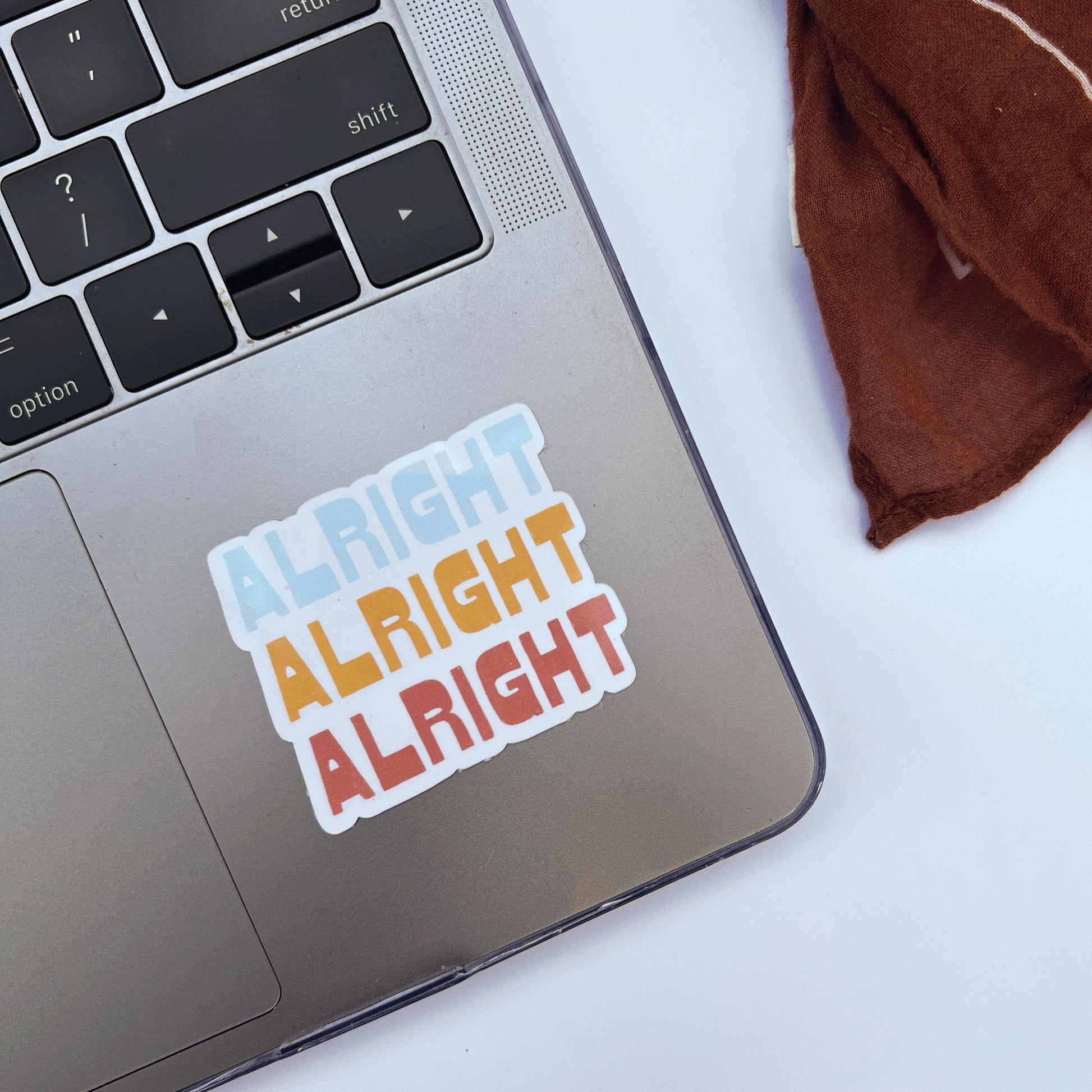 Alright Alright Alright sticker on laptop.