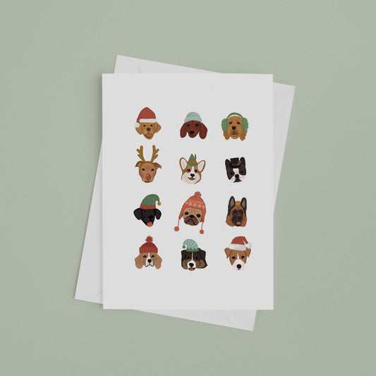 White card with 12 dogs, each in a different holiday hat