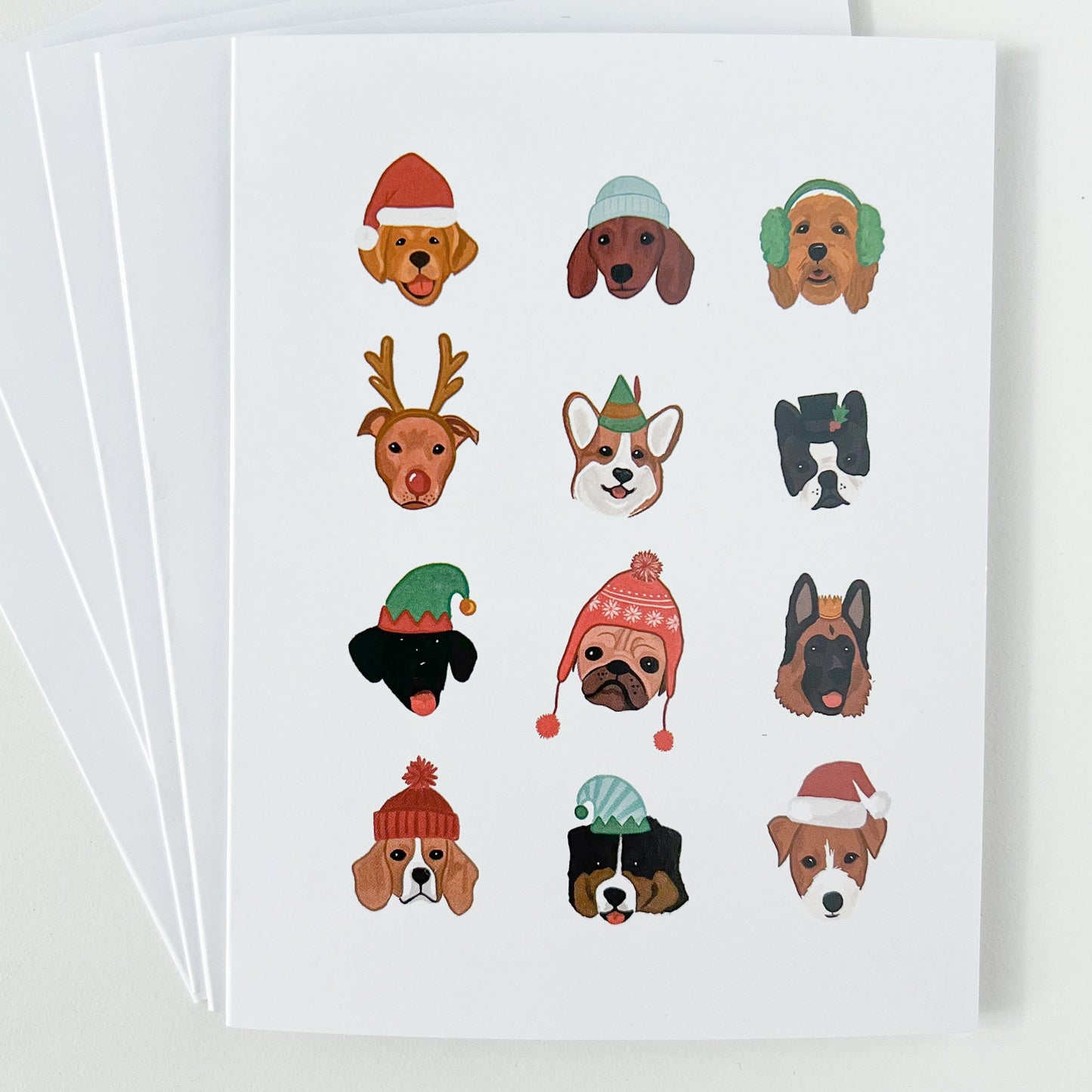 Stack of holiday cards featuring dogs in winter hats