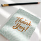 Thank You Card with white envelope shown on white desk with pencil and sunlight rays coming through window.