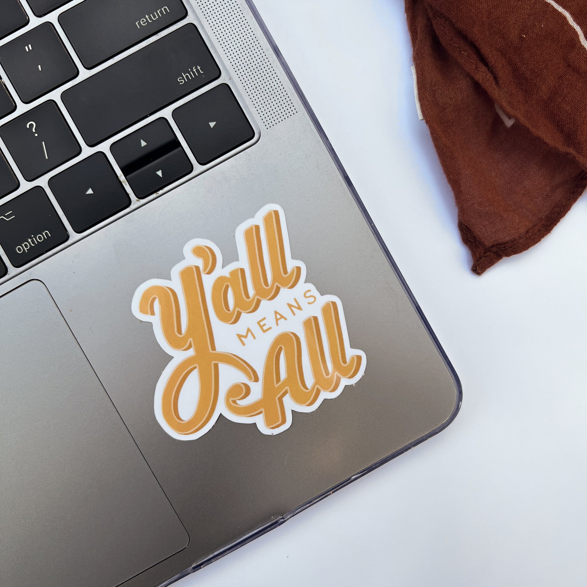 Yellow "Y'all Means All" Sticker displayed on laptop.