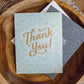 Thank you card in a teak wood bowl on a southwestern embroidered pillow