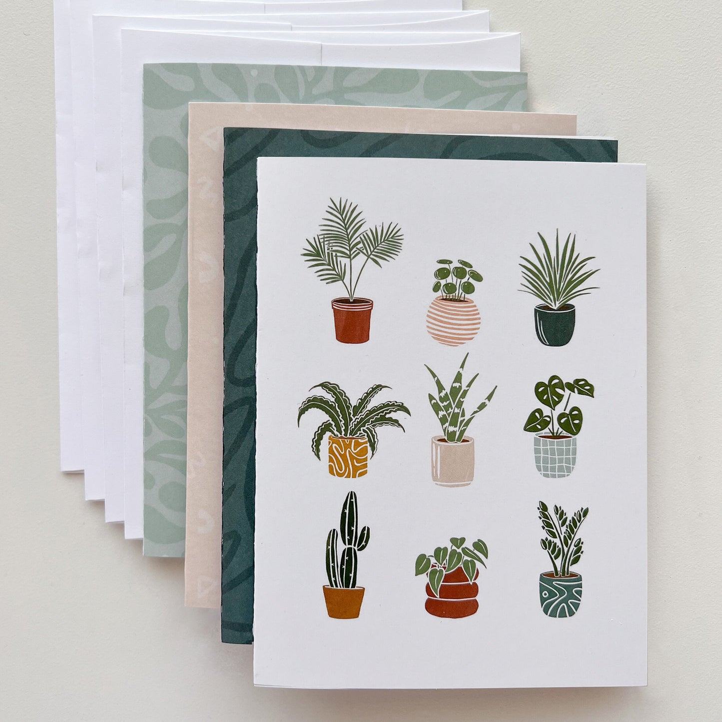 Stack of 4 mixed greeting cards with plant card on top and 4 white envelopes.
